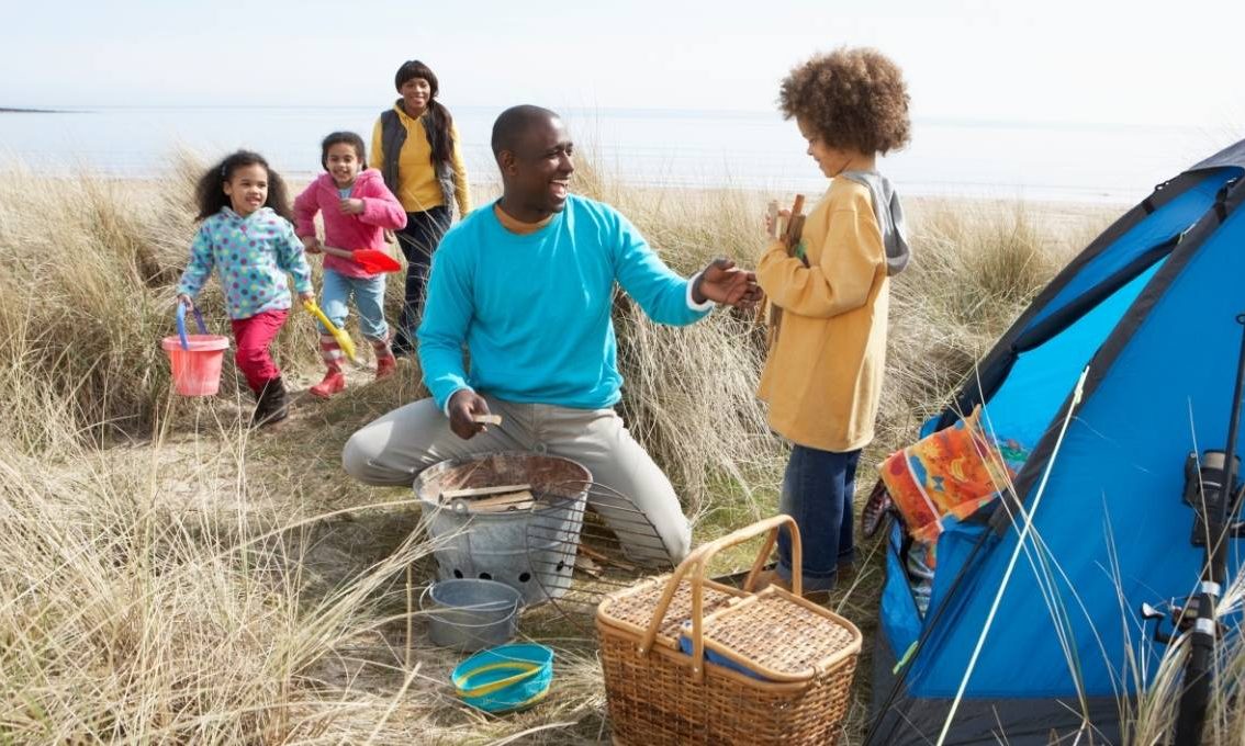 Young family set up tent on beach