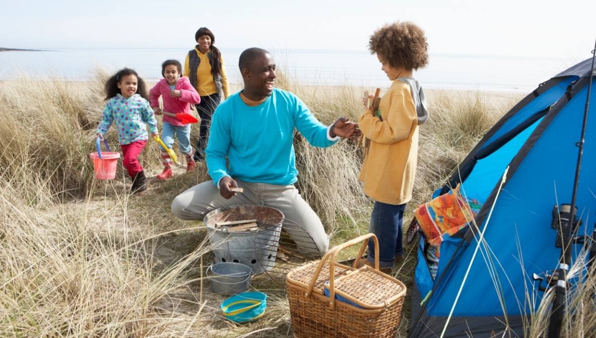 Young family set up tent on beach