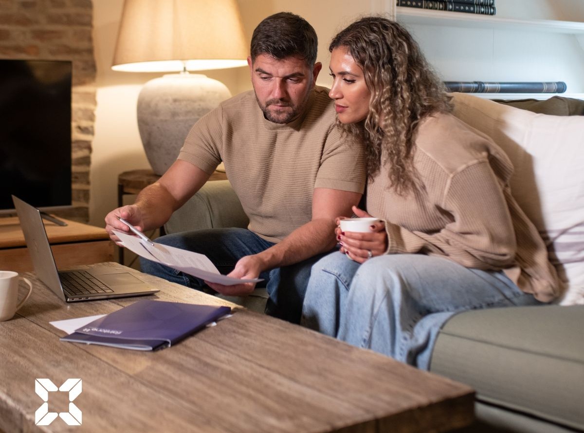 A young couple looking at documents on a coffee table in a living room